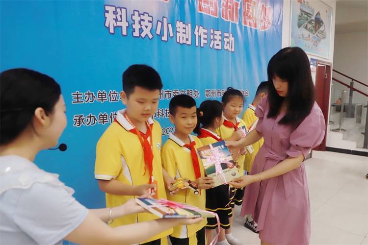 2021年7月9日鄂州市科协组织新民街小学学生在鄂州市科技馆开展社会主义核心价值观系列活动，图为开展的科技创新圆梦中华科技小制作活动，科协王雨濛部长正在为优先制作完成的学生颁发奖品.jpg